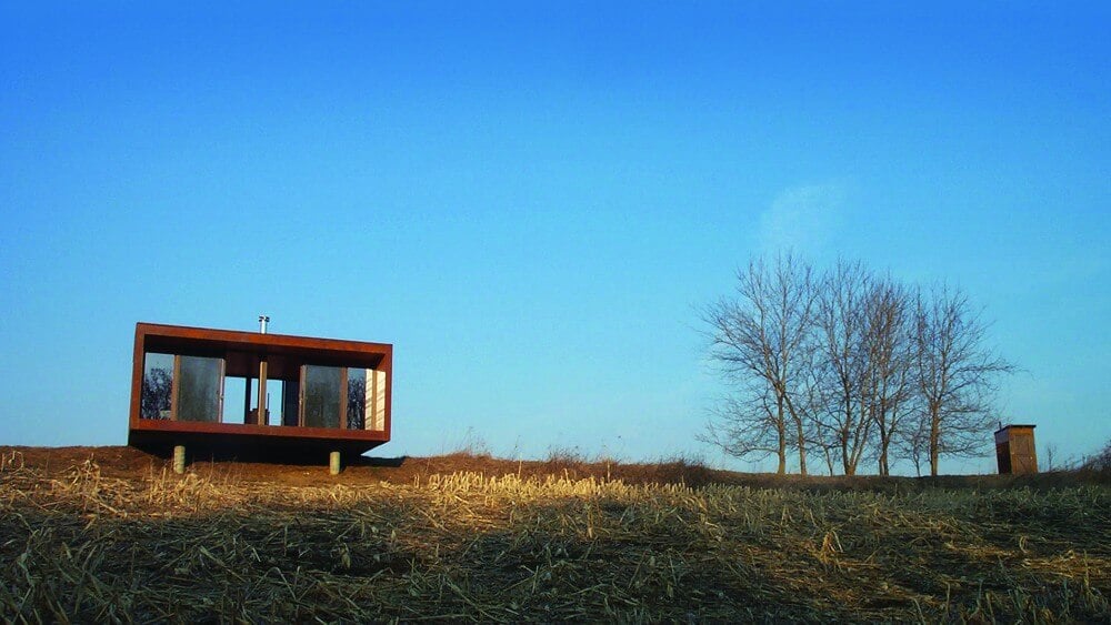 Back view of the Arado house, showcasing its compact design and all glass side overlook. 阿拉多住宅的后视图,展示了其紧凑的设计和所有的玻璃侧俯瞰。