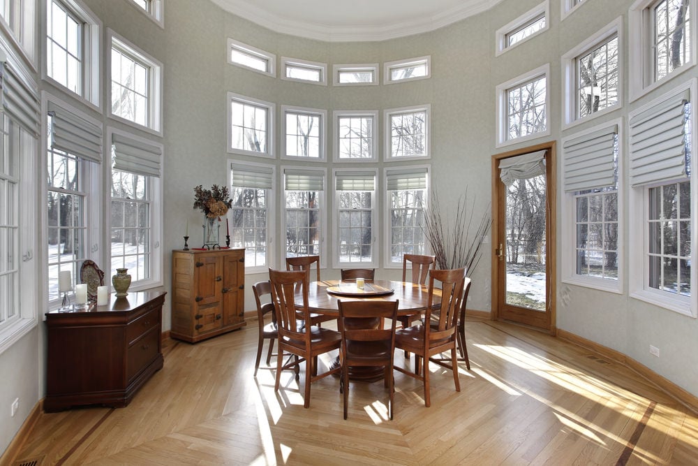 一个过渡性的阳光房，天花板很高，木制家具和肮脏的白墙。