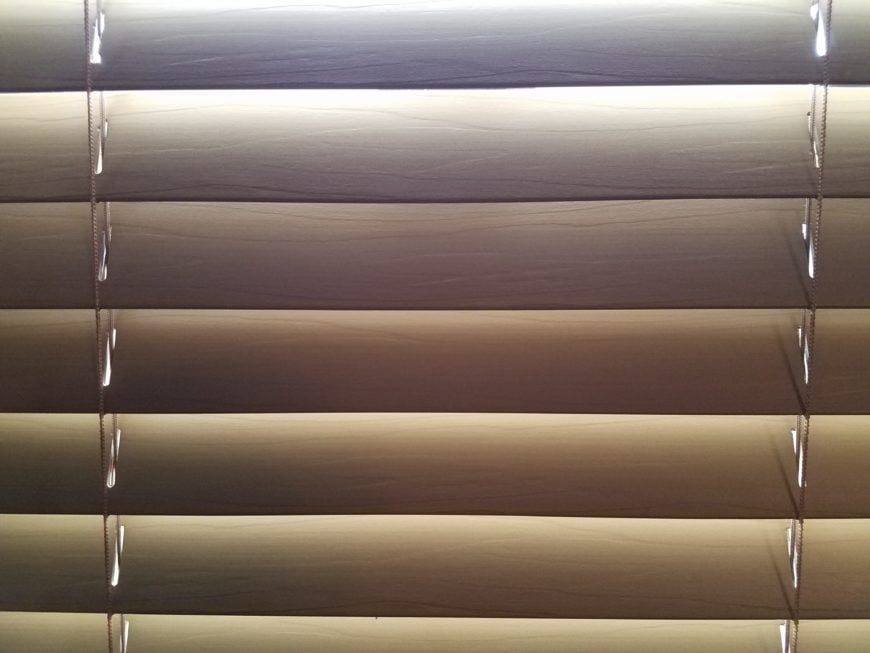 迷你棕色百叶窗与阳光照耀着