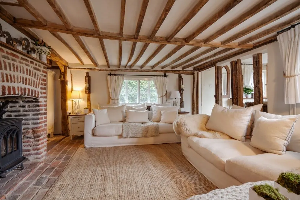 别墅风格的客厅与梁天花板和沙发面对砖壁炉。