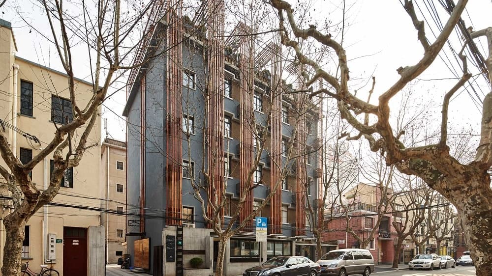 这是一个从街道的有利位置看建筑的外观,展示了简单的灰色外墙色调,辅以木条,使其具有独特的外观。