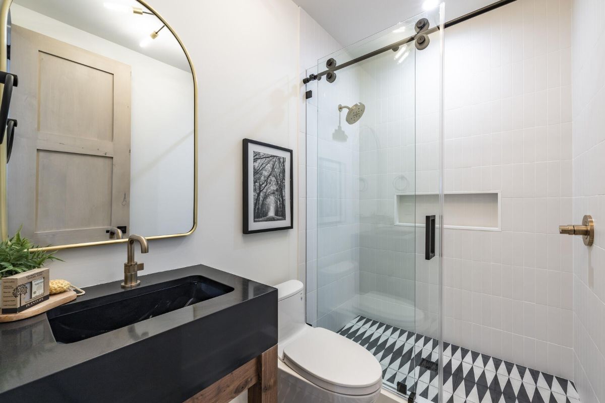 浴室设有滑动玻璃门，金色的固定装置给房间一种豪华的感觉。