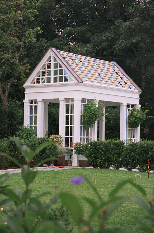 一个华丽的方形凉亭，柱子之间有格子。屋顶很像温室。