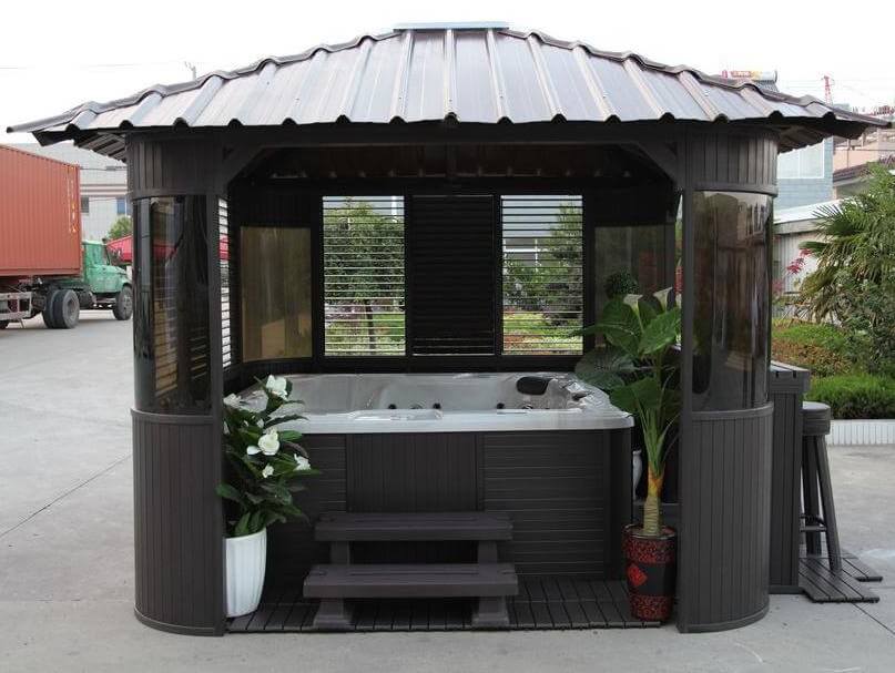 这个便携式热水浴缸凉亭的特点是铆钉屋顶，彩色玻璃窗，还有足够的额外空间来添加一些植物或毛巾架。