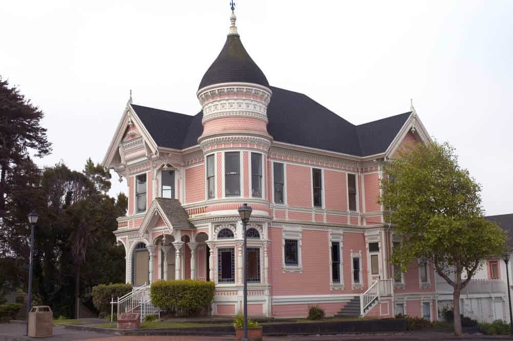 粉红色维多利亚式豪宅，白色装饰和黑色屋顶，位于加利福尼亚州尤里卡的圆形小镇。