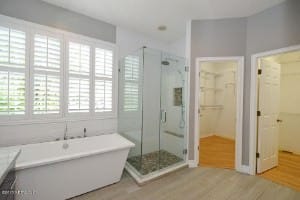 带步入式淋浴的现代主浴室，灰色墙壁和白色独立式浴缸。