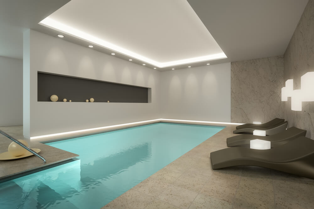 现代的室内泳池设计，带有嵌入式天花板和现代露台家具。