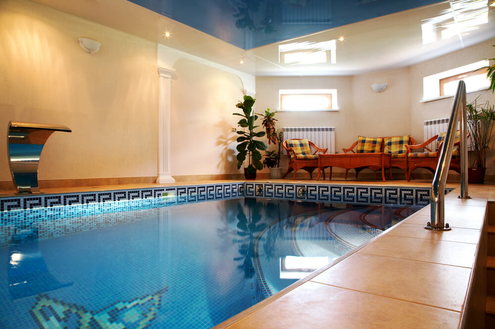 室内游泳池，蓝色天花板，桃红色墙壁和休息区。