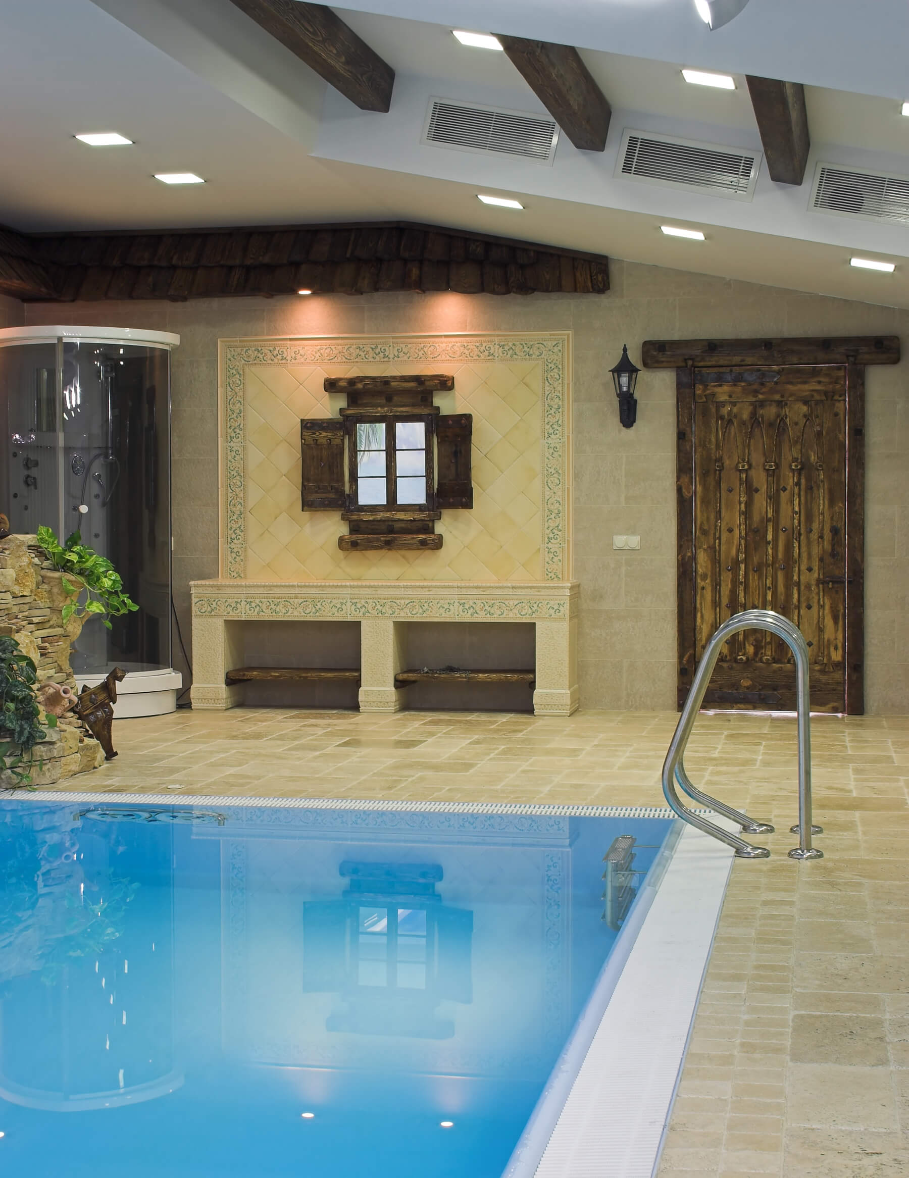 泳池房的部分视图，圆形玻璃淋浴，木门和墙壁上的瓷砖工作。