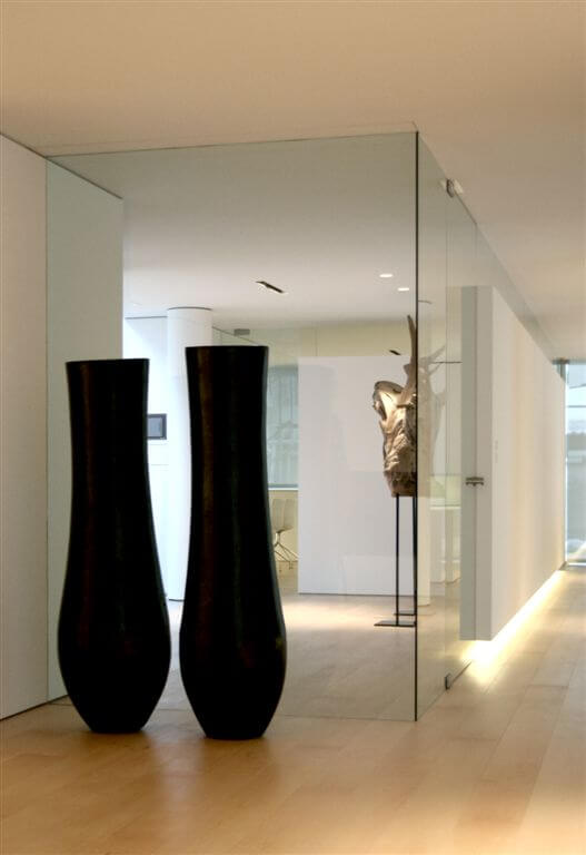 第二个走廊的角度展示玻璃墙，嵌入式照明，和大型艺术品。