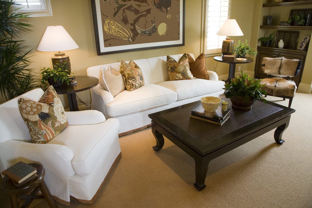 简单的客厅，一个白色的小沙发，一把白色扶手椅和一把没有扶手的古董椅子，周围是一个长方形的深棕色咖啡桌。