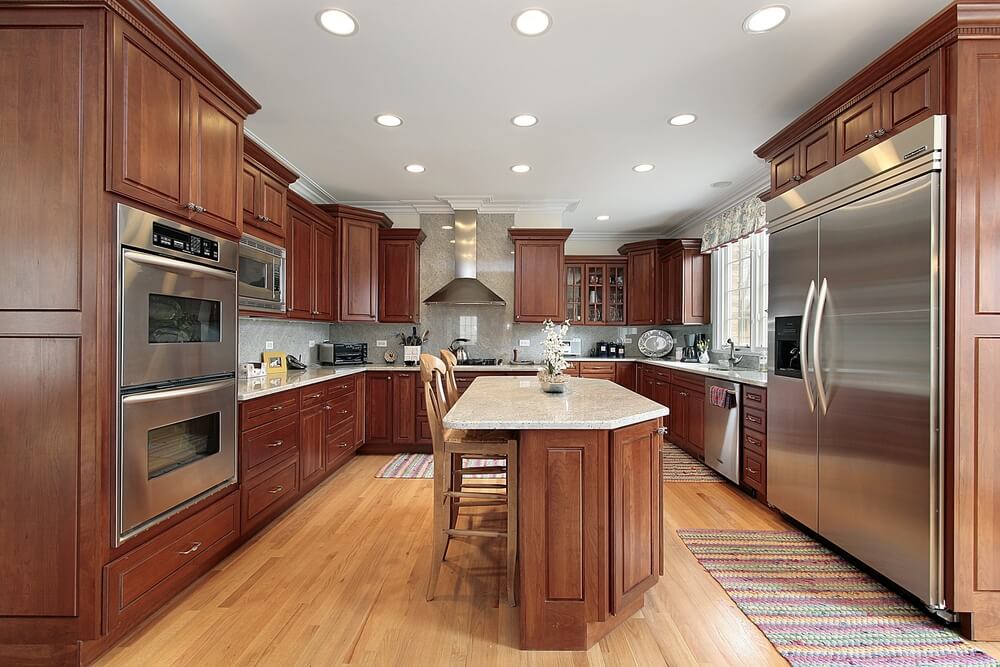 这间厨房以淡红色的深色木材和浅色地板为色调。