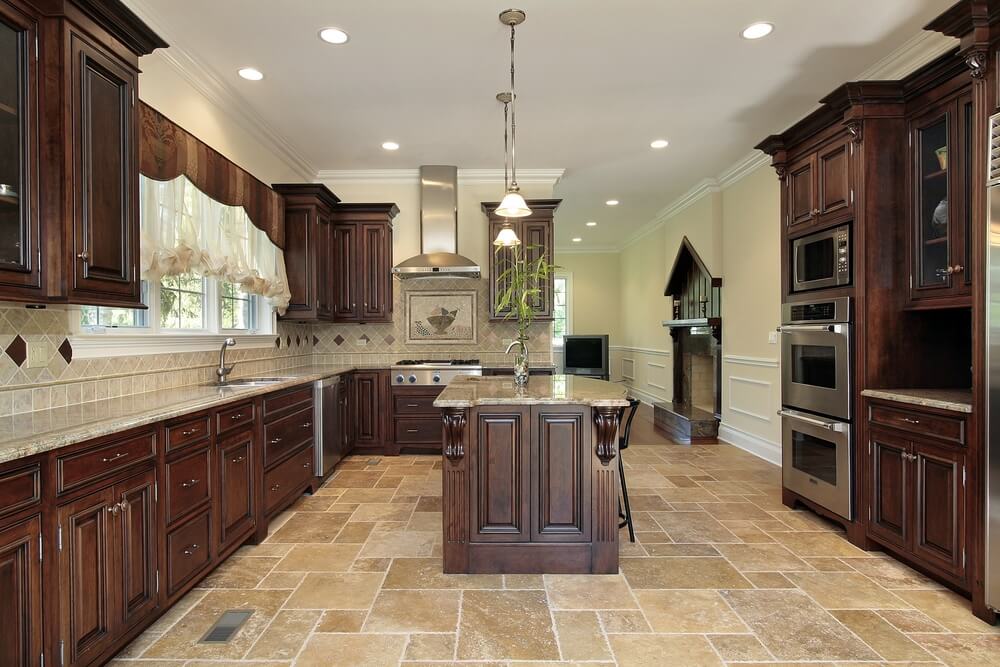 这间厨房中庄严的橱柜设计通过浅色瓷砖地板和后挡板上的深色木材得到加强。