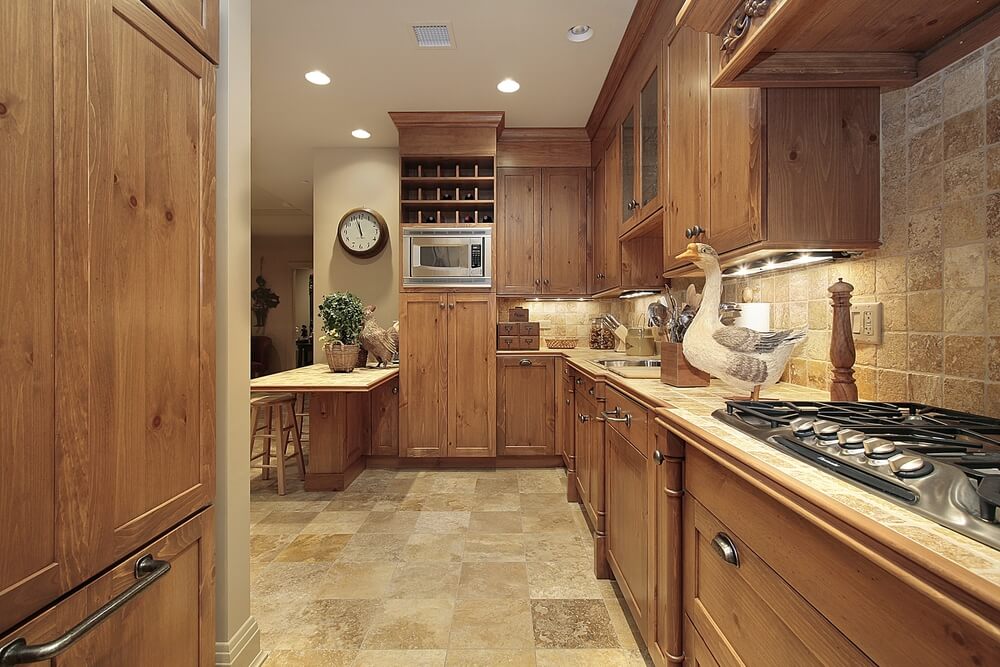 这个厨房都是统一的颜色，木质橱柜门在深色的一端，沙色瓷砖地板和后挡板在浅色的一端。