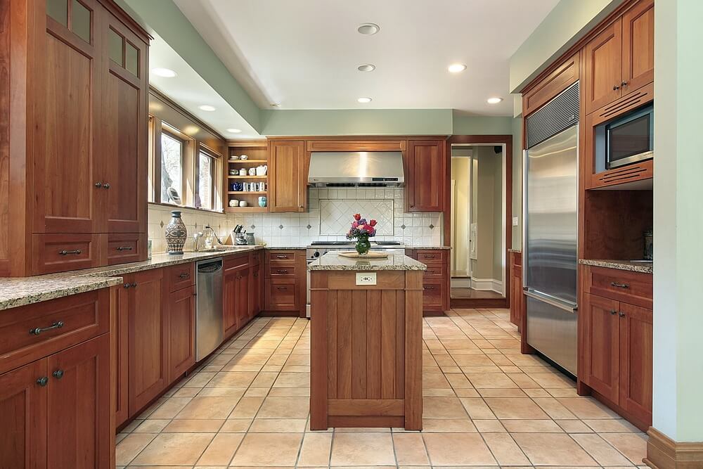 沙色瓷砖地板使自然的深色木橱柜在这个漫长的厨房中脱颖而出。