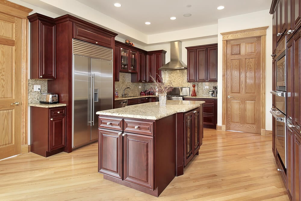 厨房的角度视图，以樱桃木橱柜和天然木地板和门的组合为特色。