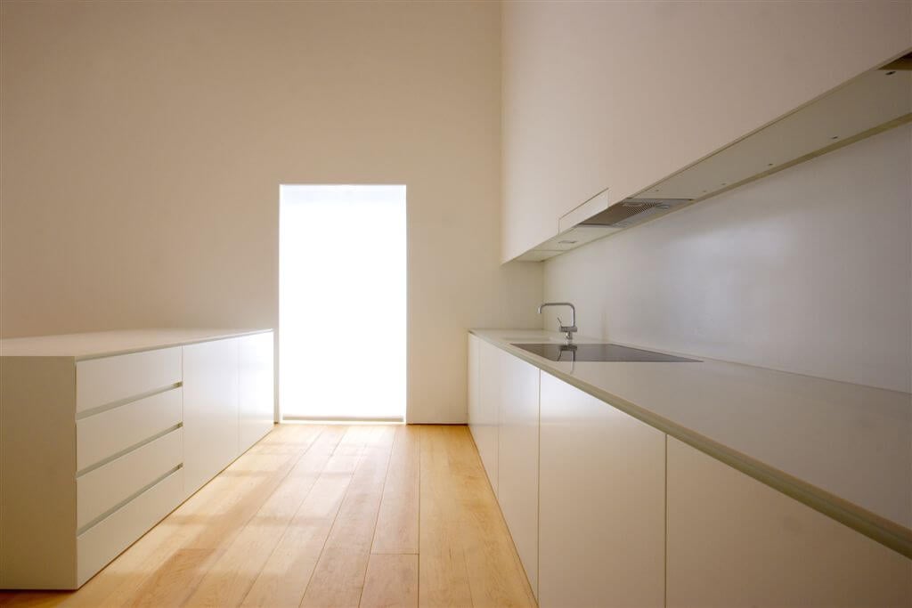 厨房的侧视图，门大小的窗户覆盖在可伸缩的阴影。