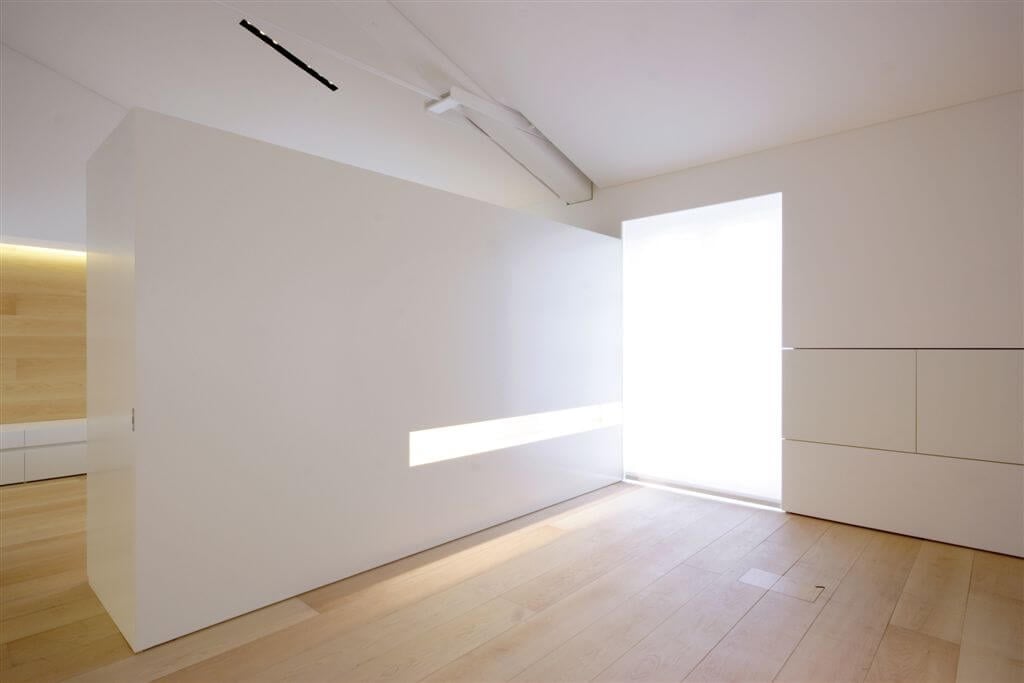 客厅的远端，分隔墙设有内置照明和隐藏的存储。