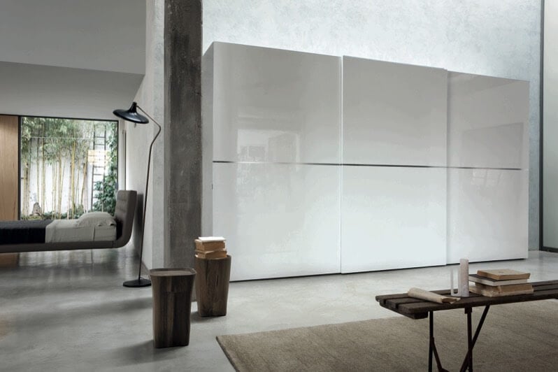 这个超现代的房间混合了天然材料、石头和雕刻的木材，有光泽的白色面板和独特的弯曲“漂浮”床架设计。