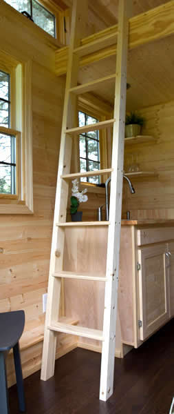 室内充满了天然未抛光的木材，厨房上方的梯子通向阁楼。