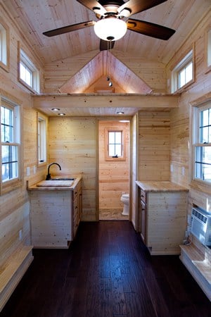 迷你住宅的内部空间最大化，小厨房旁边有小浴室。浅色天然木材覆盖整个深色硬木地板。