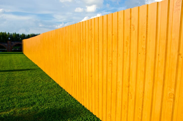 轻盈的天然木质隐私围栏设计在郁郁葱葱的草坪上格外显眼。