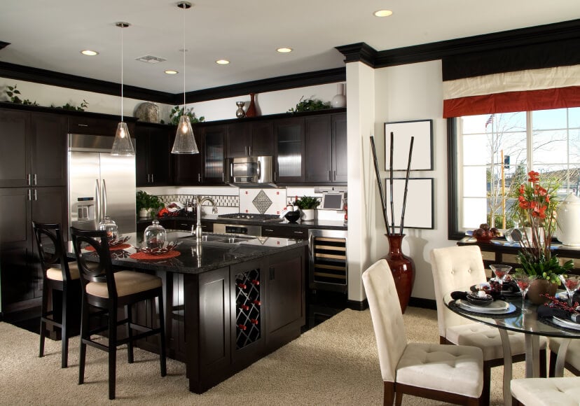 开放式厨房的高对比度白墙和深色染色木材设计在视觉上将空间与用餐区分开。