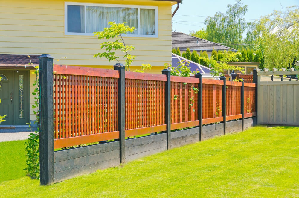 现代格子栅栏由黑色染色木桩和底座组成，配以浅红色调体。
