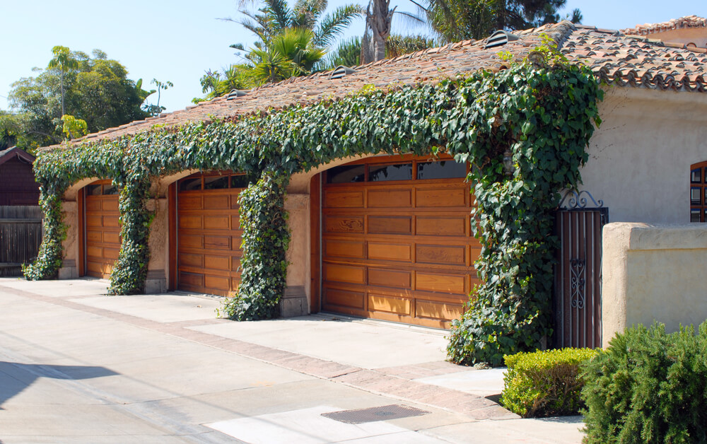 侧向车库在常春藤覆盖的土坯立面上框架了三扇天然木门。