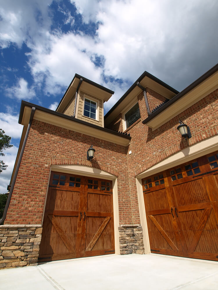 这个砖砌住宅具有独特的车库，门面向角落的两个角度:左侧的单木马车风格的门，右侧的双尺寸匹配门。