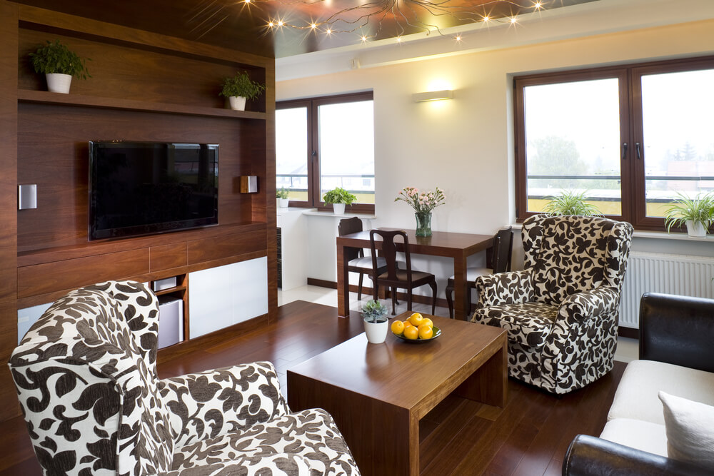 另一间小客厅里有黑白图案的扶手椅，旁边是一张双人沙发和一张长方形的木制咖啡桌。这个房间可以用作客厅或家庭娱乐室。