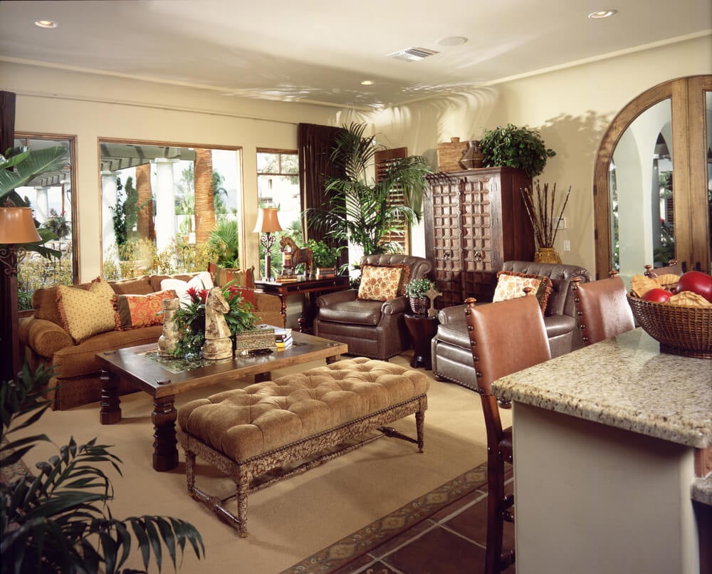 豪华的客厅充斥着多种异国情调的纹理，包括大理石吧台桌，皮革轻松椅，填充橙色沙发和硬木咖啡桌旁边的大型簇绒长椅。