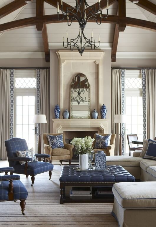 庄严的客厅以米色和海军蓝的大胆混合为特色。奥斯曼咖啡桌、扶手椅、枕头和壁炉架上的花瓶都是蓝色的，在其他中性的环境中脱颖而出。