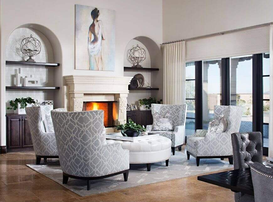 白色和灰色的特征贯穿了这个高天花板的客厅，四把高靠背椅围绕着巨大的白色皮革圆形凳。
