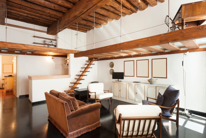 高对比度的客厅以黑色地板和白色墙壁为特色，采用天然原木天花板设计和木质阁楼空间，支撑货架和办公空间。