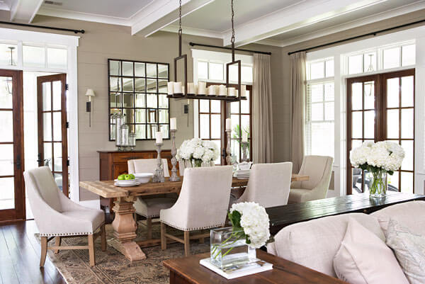 精心细致的客厅以各种色调的丰富天然木材为主导的中性色调，包括大型雕刻餐桌。天然木质法式门和白色窗框环绕着空间。