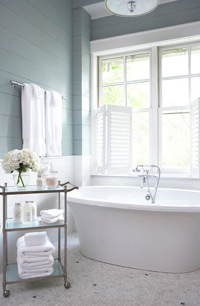 主浴在宁静的白色，棕褐色和海蓝宝石的阴影，持有这个深白色底座浴缸在图案瓷砖地板上。