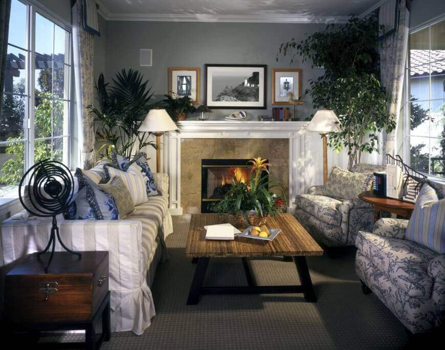 舒适的客厅，奢华的装饰:大理石和白木壁炉环绕，茂密的木咖啡桌，厚垫座椅，两边的大窗户，自然采光。