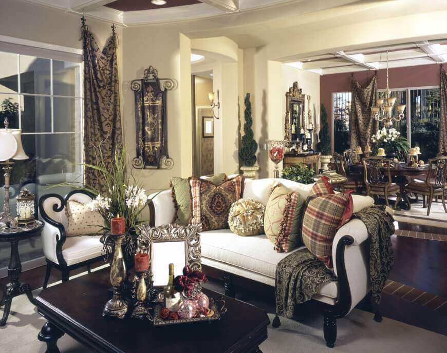 这个奢华的房间充满了各种纹理和色调，从深色的木咖啡桌和沙发框架，到硬木地板上的砖纹，再到米黄色墙壁上的金色窗帘和挂毯。