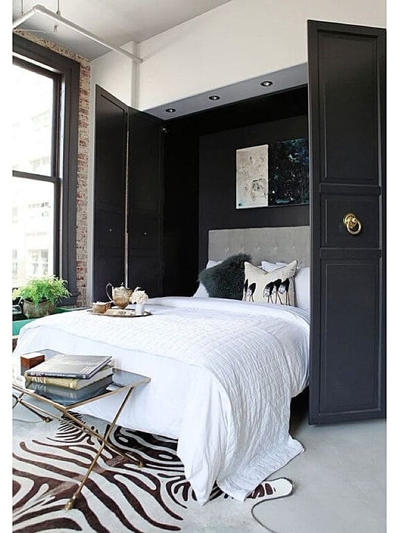 这是一张墨菲风格的床，带有深灰色的门，与床尾的斑马印花地毯很好地融合在一起。