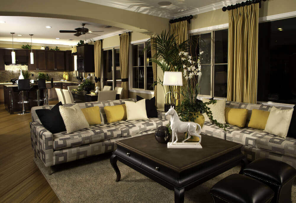 微妙的黑色，白色和金色主题贯穿这个巨大的开放式客厅空间，从窗帘到双皮革脚垫