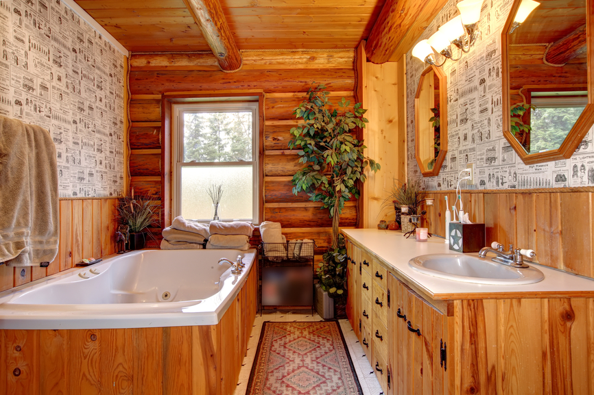 独特的乡村风格浴室具有天然木质梳妆台和较低的墙壁，浴缸框架，原木风格的外墙和天花板。