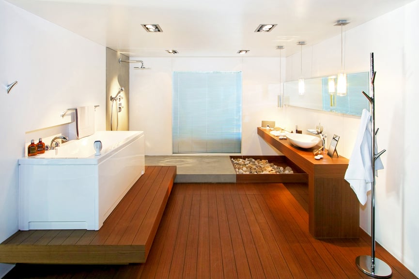 引人注目的禅宗风格体现了这个浴室，郁郁葱郁的天然木地板和凸起的浴室平台，与之配套的极简主义梳妆台，在全白色的环境中。