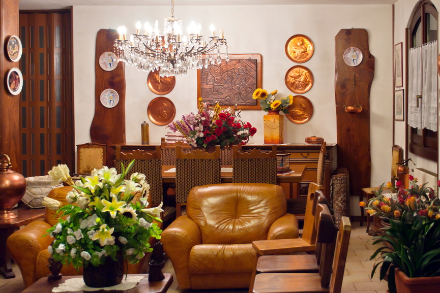 细节丰富的客厅与郁郁葱郁的木质餐厅共享空间，浅棕色的皮革椅子与整个木质色调相匹配，在米黄色的瓷砖地板上。