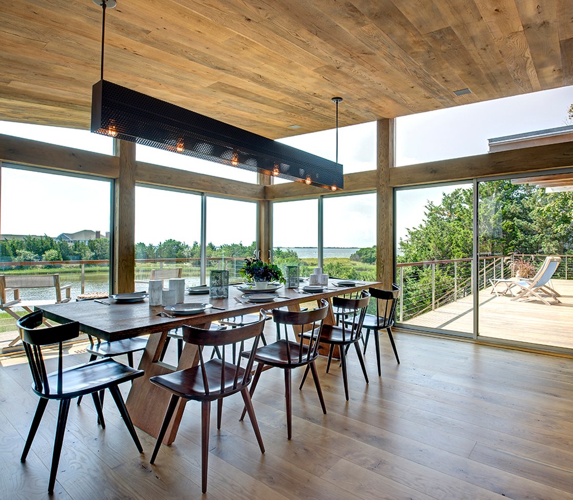 主要开放空间形成内部的主体包括这个充满阳光的餐厅里,有架空金属照明架上面挂着冗长的木头餐桌。滑动玻璃门与大型天然木梁框架周围的外部结构。