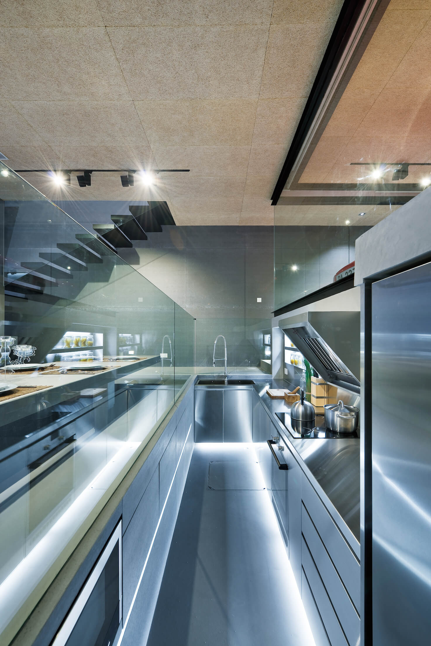 超现代厨房的近景，利用新颖的下沉空间，沐浴在拉丝铝材料中。
