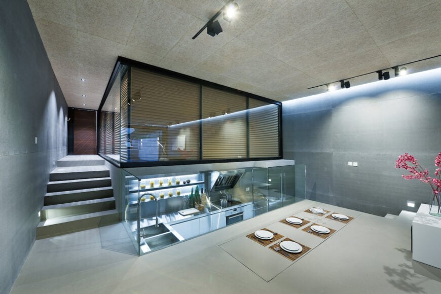 这个家可以看到车库窗帘和餐桌的封闭位置。低矮的玻璃墙将厨房空间与主体分隔开来，而右侧的台阶允许进入。