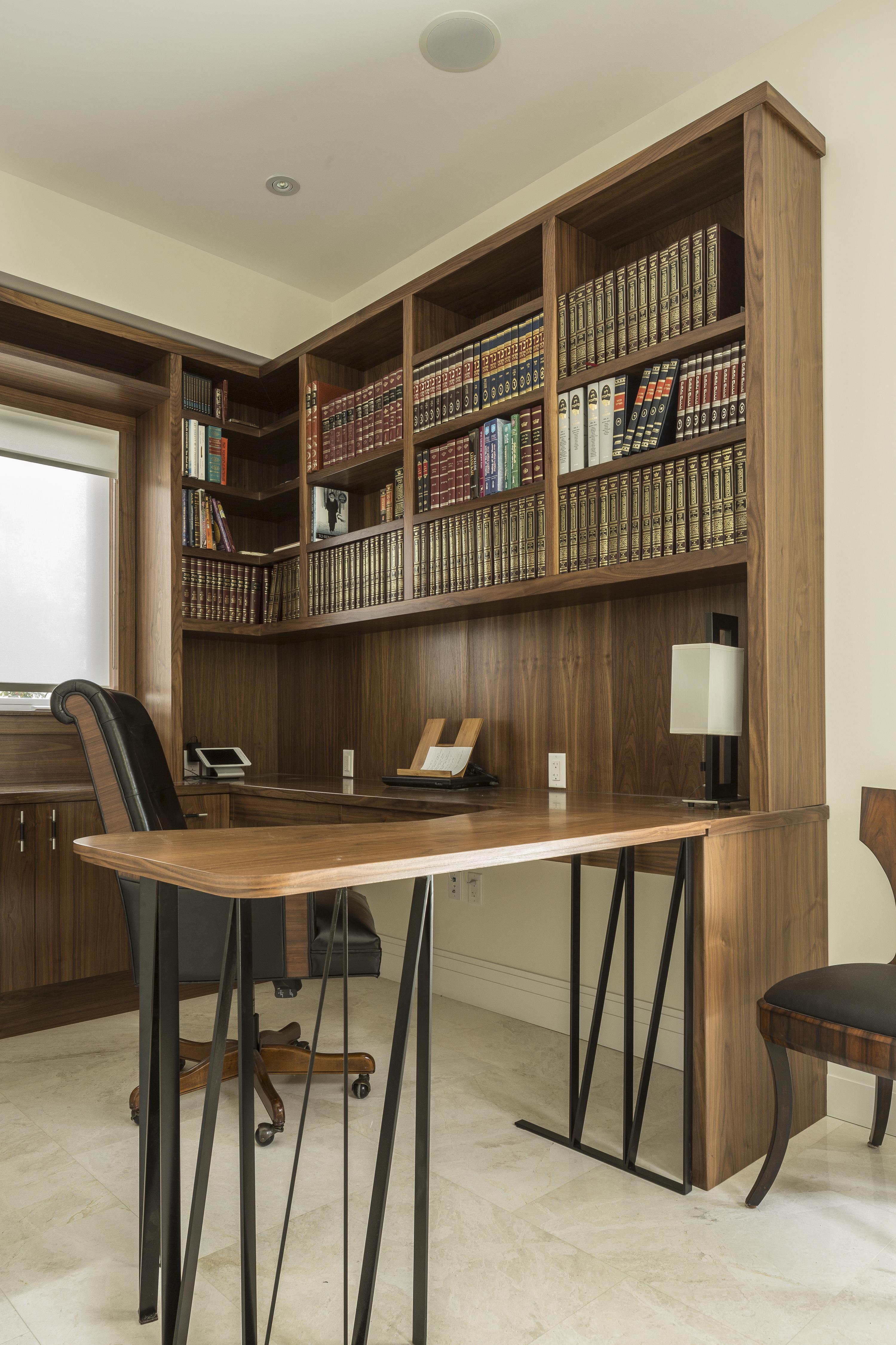 办公室的特点是更多的丰富的木镶板，延伸到墙壁结构，橱柜和这个大的环绕式办公桌，头顶上有大量的书架。