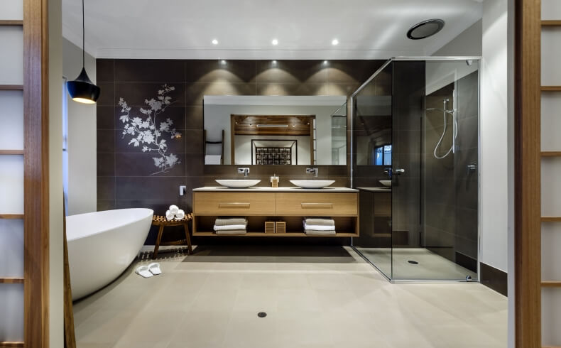主浴室的景色显示了带有双容器水槽的天然木质梳妆台，纯玻璃步入式淋浴，以及安装在深色镜子上的精致花卉的详细视图。