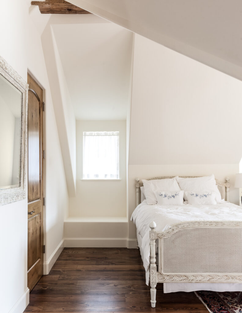 这个房间的特色是另一个白色油漆的床架，与丰富的硬木地板形成对比。